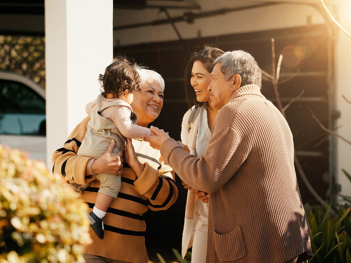 Los abuelos reciben a su hija y al bebé en la entrada de casa.